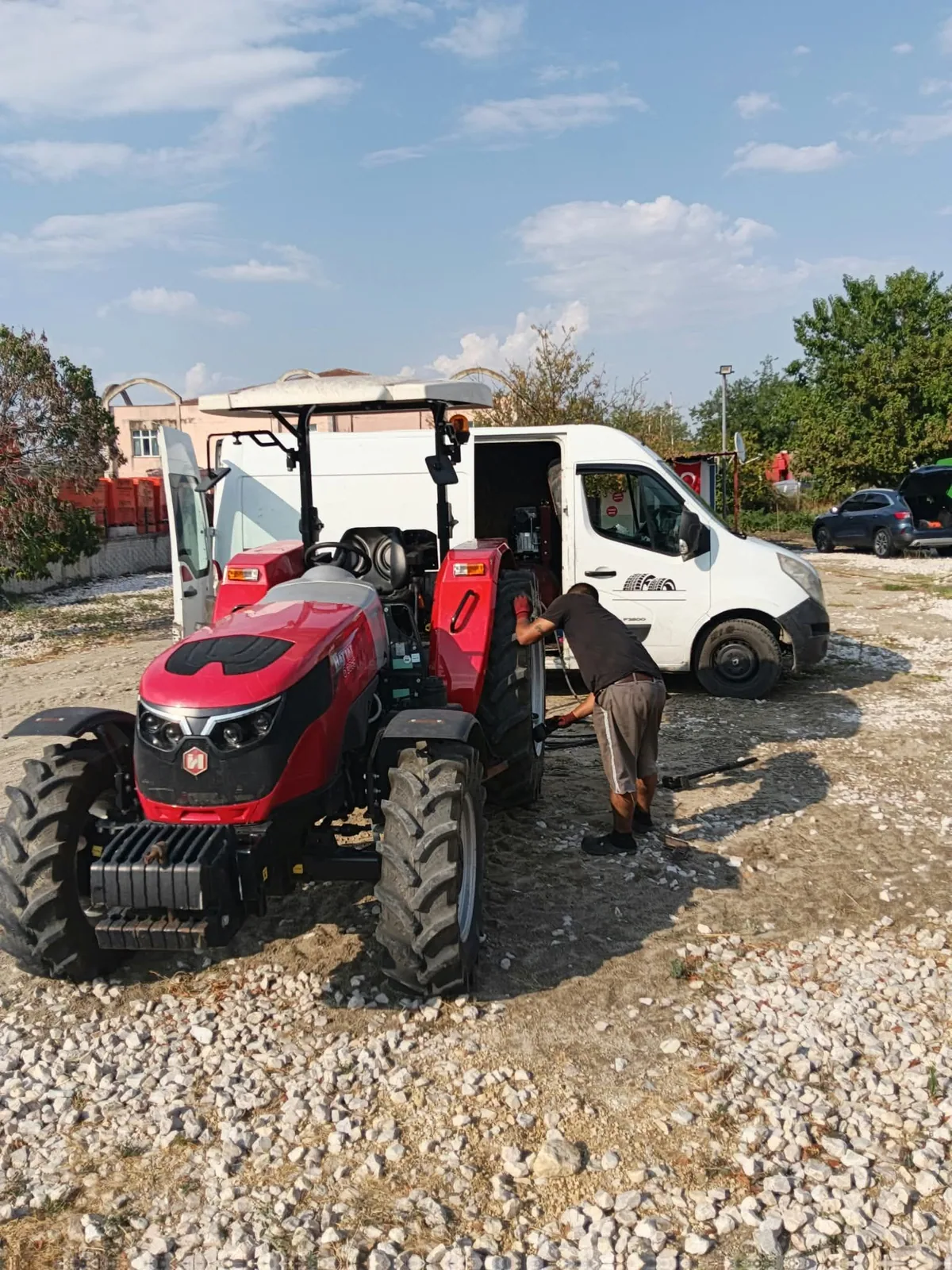 Traktör lastiğine sahada müdahale, servis aracının yanında